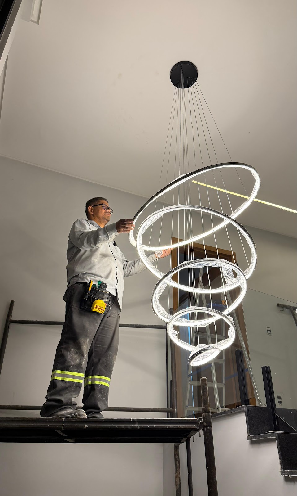 Técnico da LF Soluções instalando luminária de LED em ambiente residencial